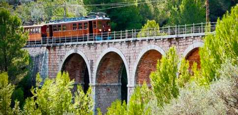There is no better way to see the countryside than on the century-old wooden and historic train from Palma to Soller (Photo credit: Free Tour)