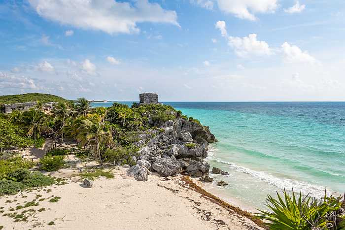 Caribbean beach with Mayan Ruins of Tulum in the background